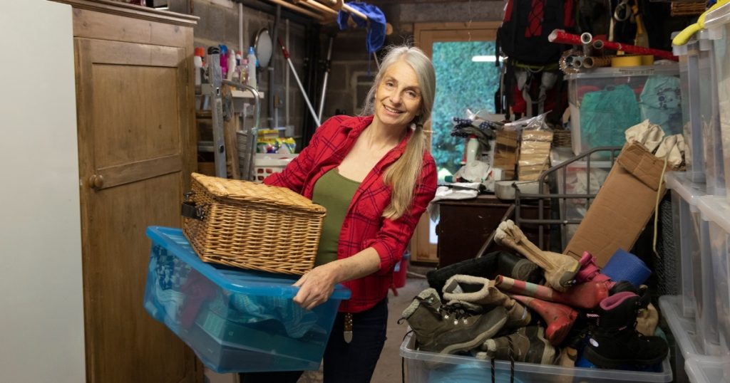 Woman moving boxes in a cluttered garage